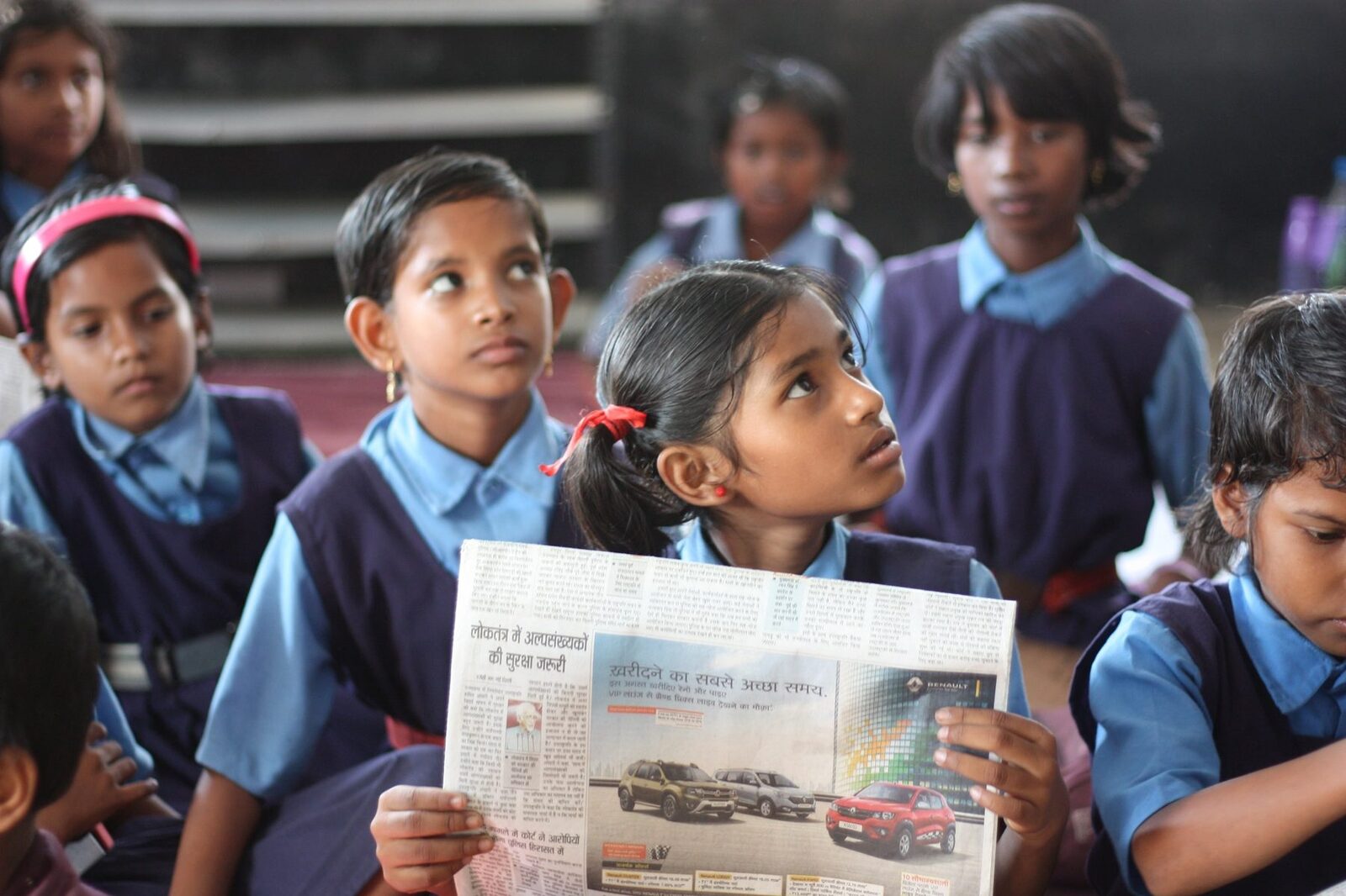A student reading a newspaper, reflecting eLMNOP's media coverage and community impact.